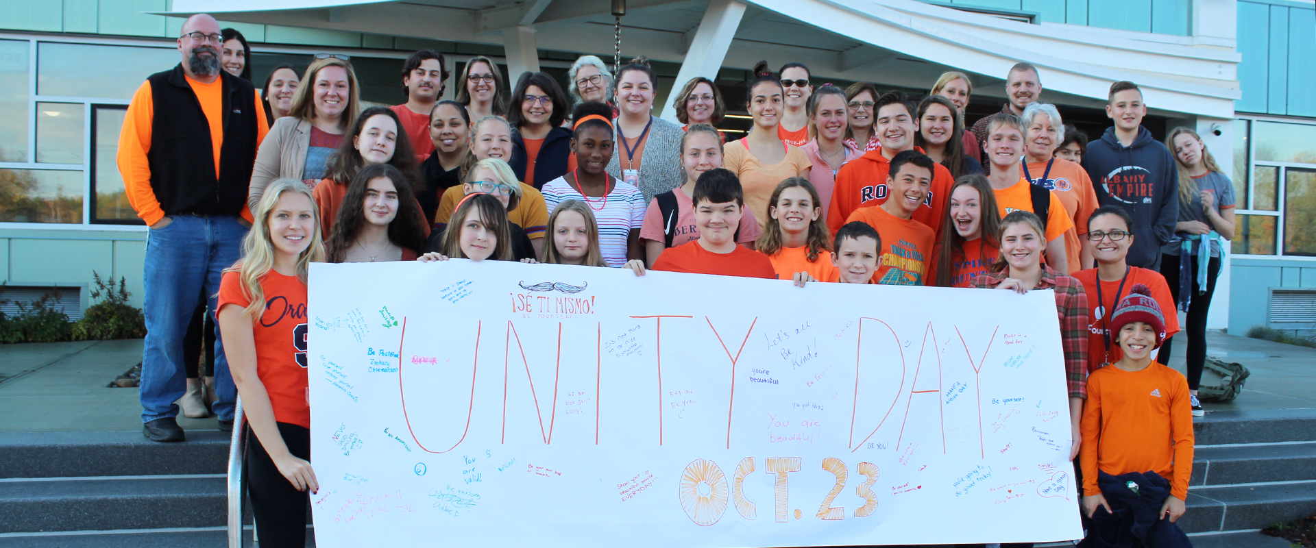 Students, faculty and staff with Unity Day banner