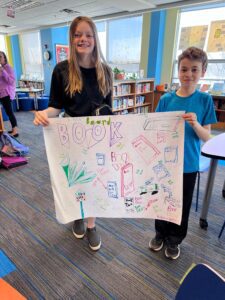 Students With Poster For April Book Drive
