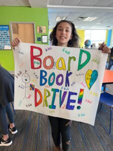 Students With Poster For April Book Drive