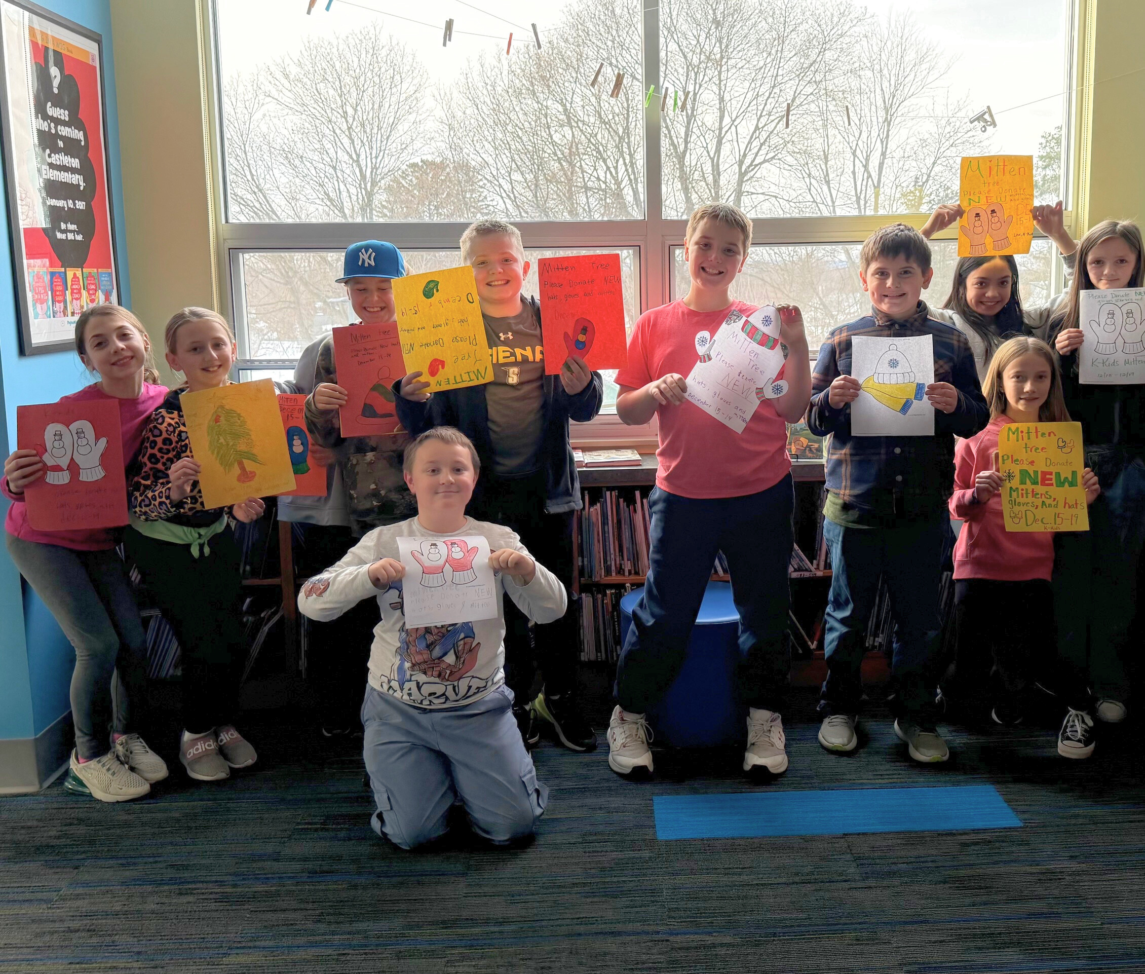 The Castleton Elementary School Kiwanis Kids posing with signs for their winter clothing drive.